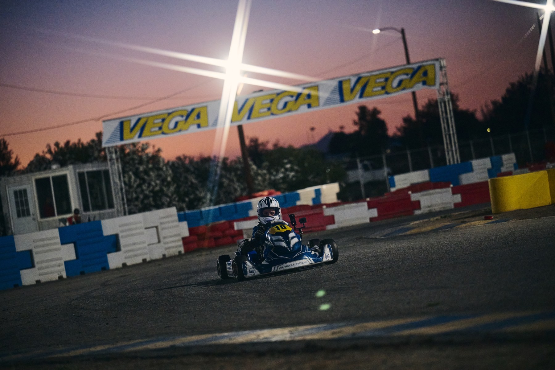 Reid Eck racing kart number 10 on track at Apex Motorsports Park under the lights
